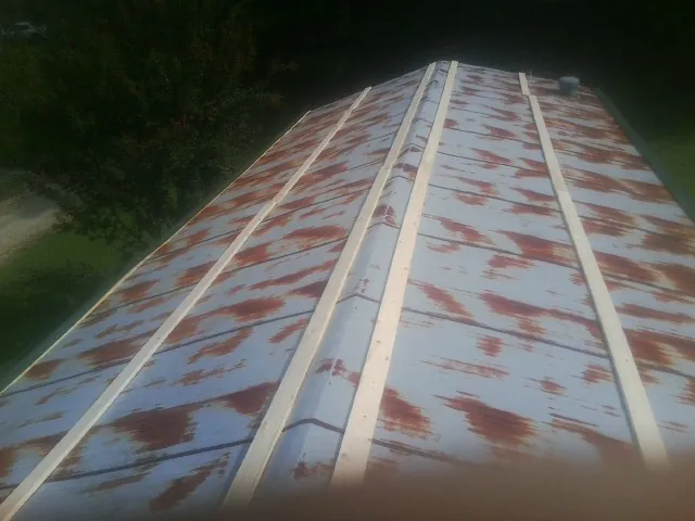 Rusted metal roof panels with new wood purlins before replacement — Storm Damage Roof Repair in Martindale by Roofing Brothers